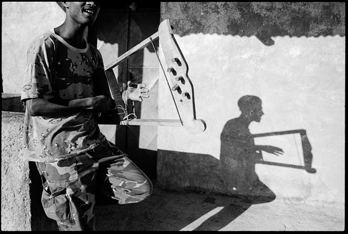 A soldier plays a kirar singing in the early morning light - © Giulio Napolitano